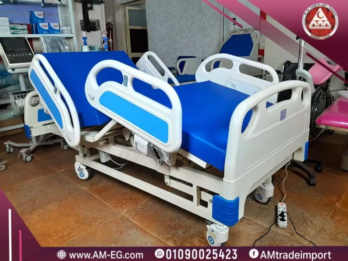 صورة طبيعية لسرير طبي كهربائي ثلاث حركات بالريموت، حواجز ABS مرفوعة، هيكل أبيض متين، مرتبة طبية زرقاء، وأربع عجلات بمصدات.