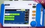 A close-up, real-life image of the front panel of a blue and white ventilator, featuring a 7-inch touchscreen and control buttons