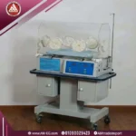 صورة حقيقية أمامية لحضانة أطفال مبتسرين AM3000، مع غطاء شفاف ولوحة تحكم باللون الأزرق، مزودة بشاشة رقمية وحساسات حرارة على قاعدة متحركة.