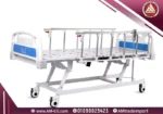 سرير طبي كهربائي Saikang ICU بخمس حركات بوضع مسطح، هيكل أبيض متين، مرتبة طبية زرقاء، مزود بريموت، حامل محاليل، وأربع عجلات صامتة بوضع مرفوع.