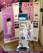 صورة طبيعية أمامية في مستشفى جامعي لجهاز فينتليتور MEK MV2000 EVO 5 بشاشة TFT تاتش 15 بوصة، بتصميم أبيض بقاعدة لها أربع عجلات.