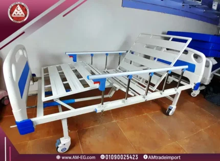 Real image of Manual 2-crank hospital bed fully raised, white metal design, without a mattress, with four wheels and safety side rails