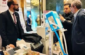فريق شركة الأمين ميديكال يقوم بعرض وشرح مزايا جهاز تنفس صناعي أبيض وأزرق اللون بشاشة تاتش لدكتور متخصص داخل قاعة المؤتمر